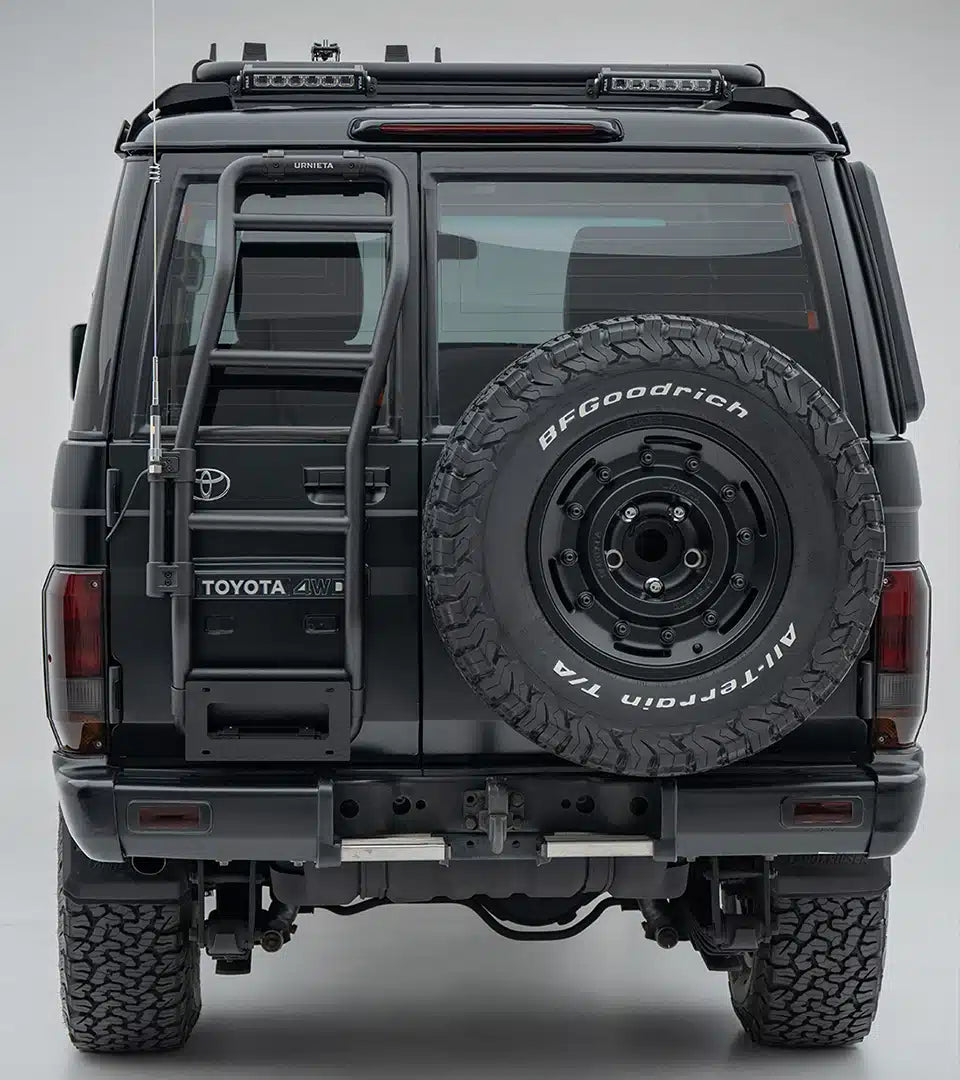 Back view of a Toyota vehicle with a spare tire mounted on a gray background