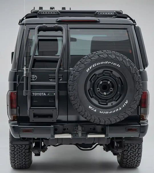 Back view of a Toyota vehicle with a spare tire mounted on a gray background