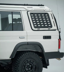 White off-road vehicle with a roof rack and additional storage compartment on a gray background